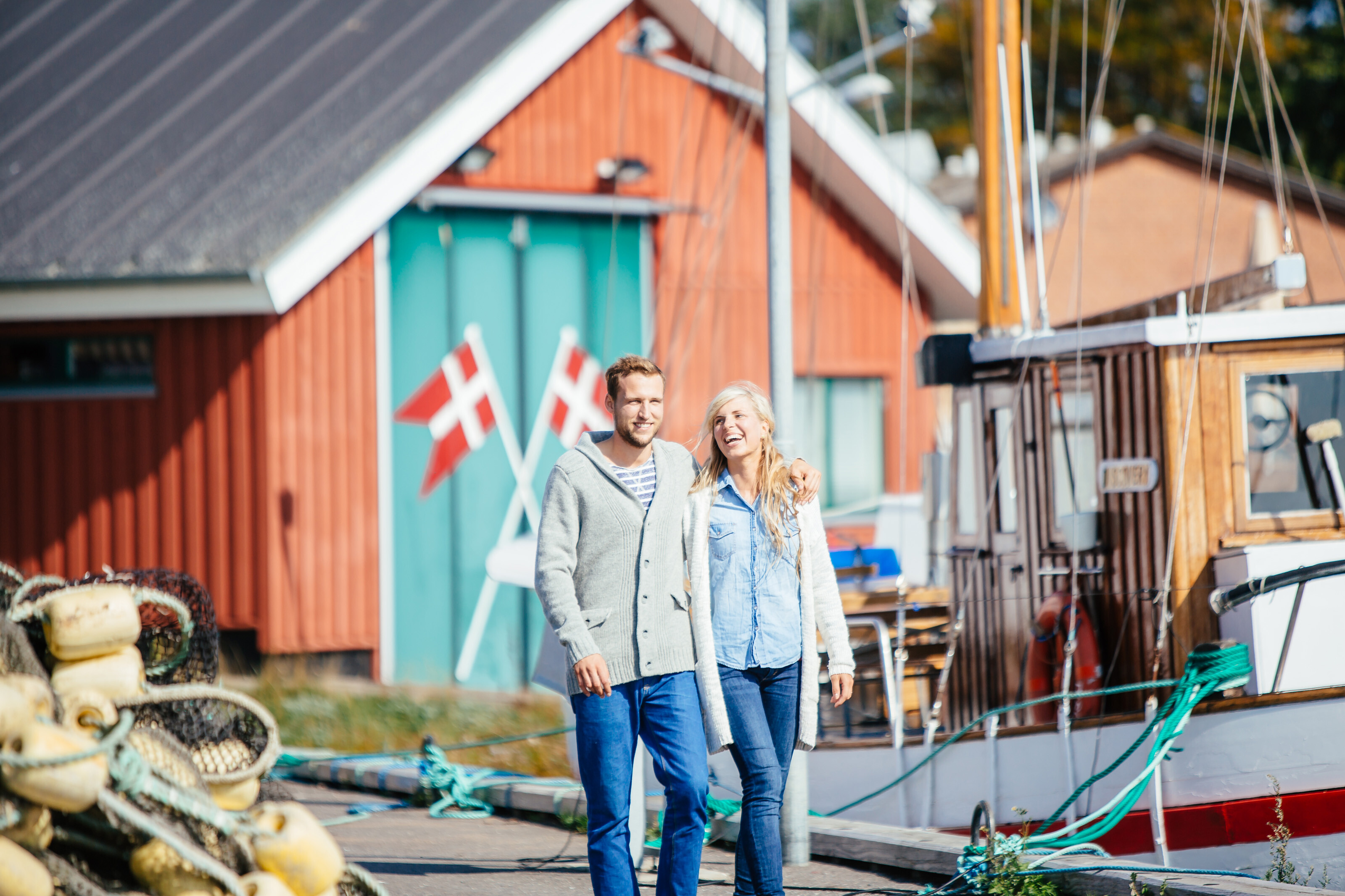 Couple walking along the harbour in Denmark smiling
