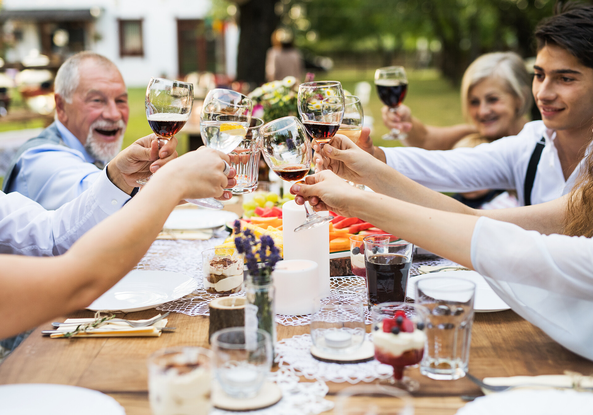 Folk skåler i rødvin rundt om et bord