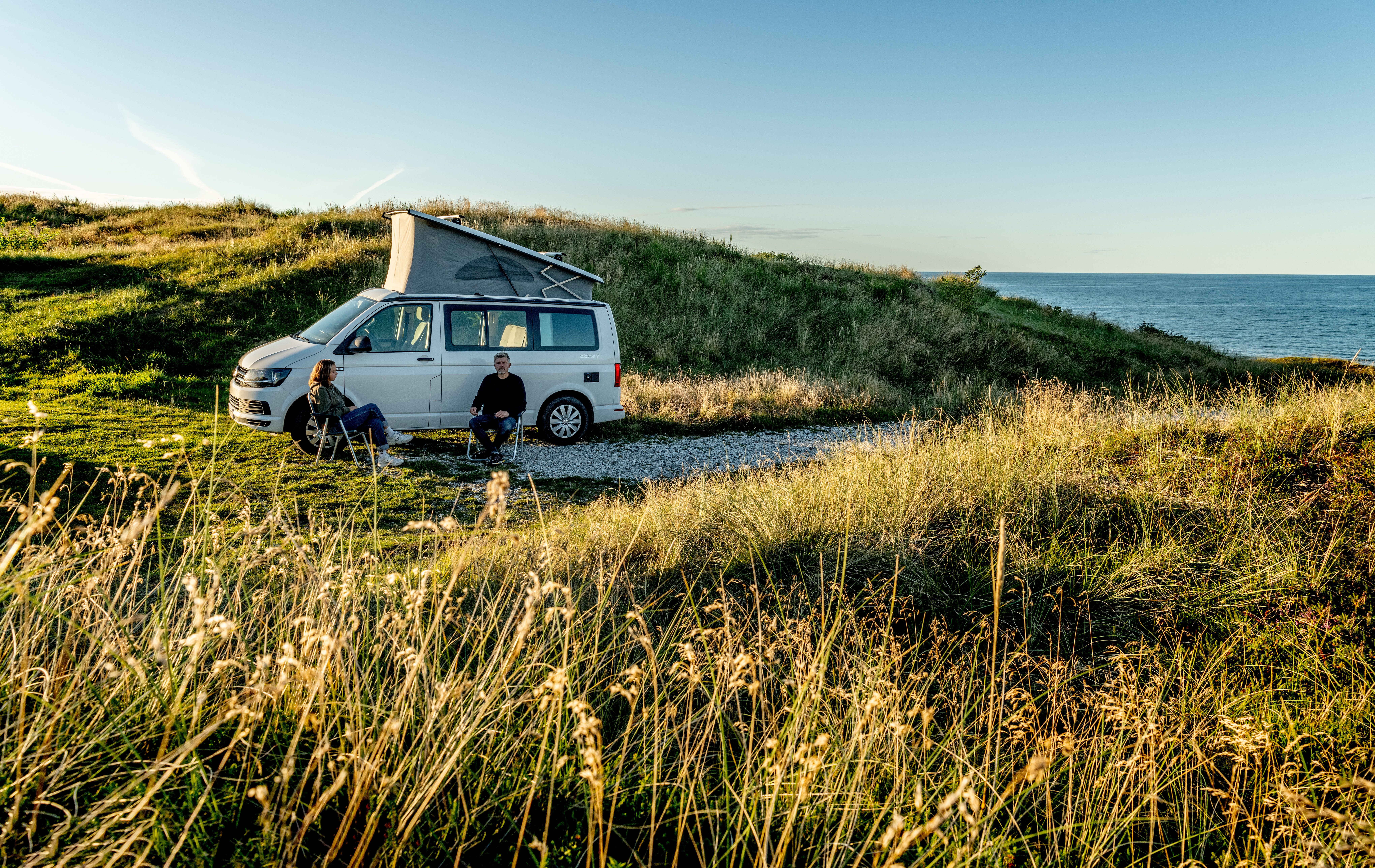 Vanlife: 2 Menschen sitzen vor eigenem Camper in Dänemark