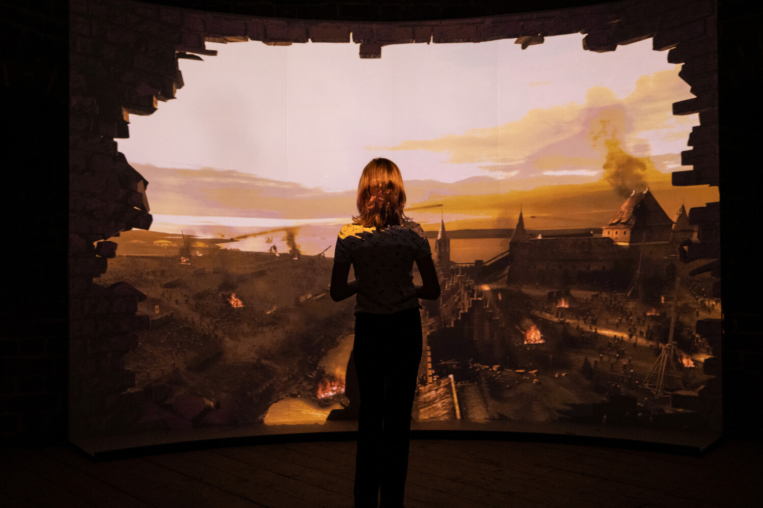 Eine Besucherin steht vor einer audiovisuellen Ausstellung im Burgzentrum Vordingborg