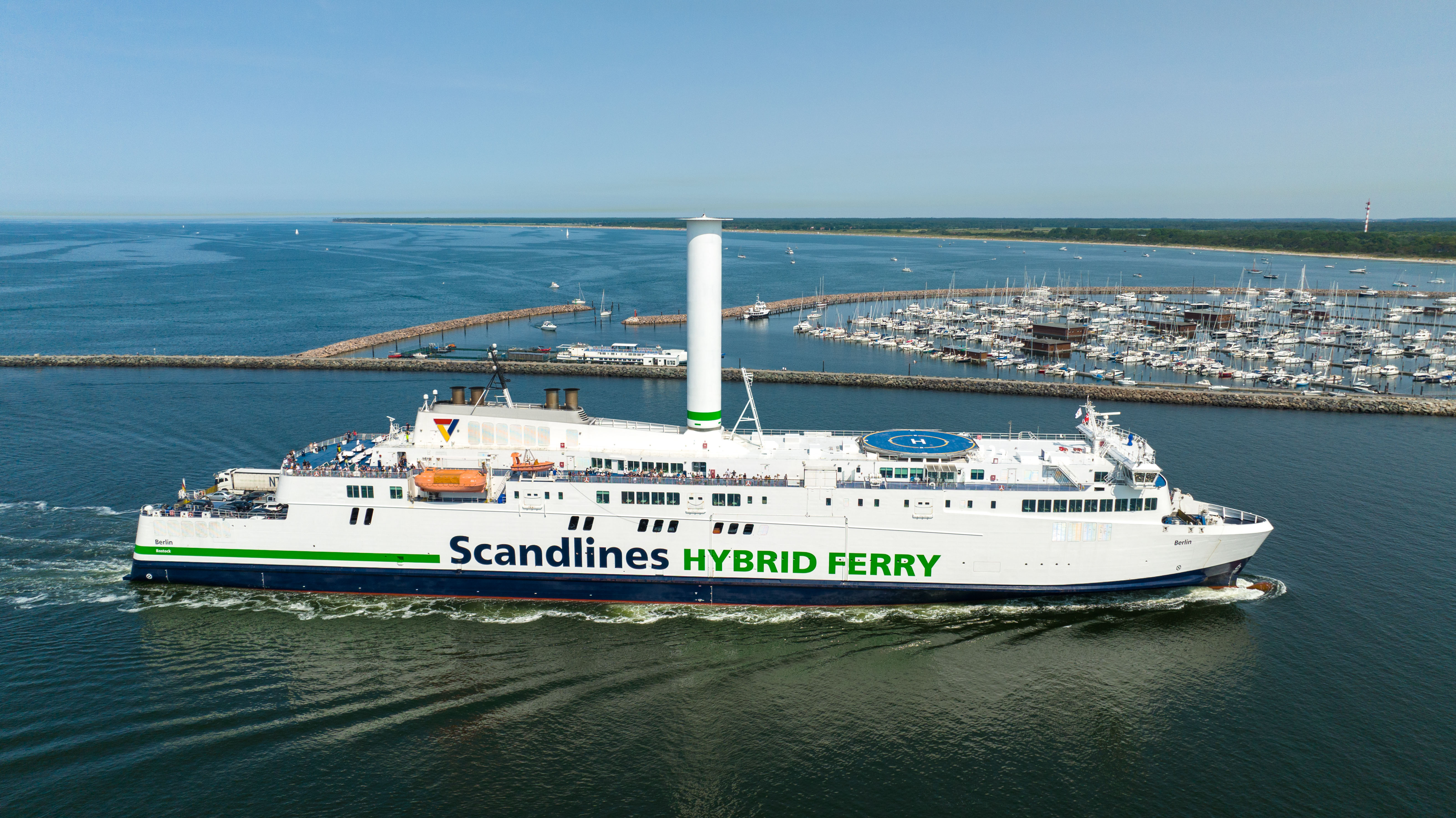 Scandlines Hybridfähre fährt zum Hafen in Rostock bei dem Yachthafen