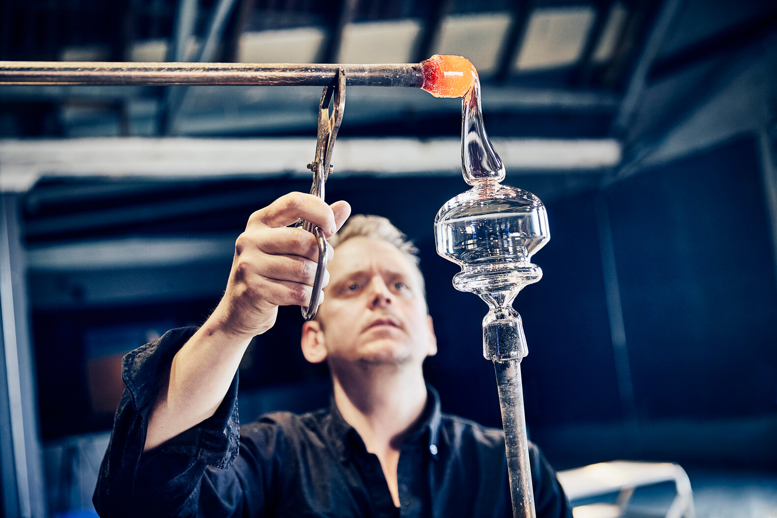 Mann kreiert Glas per Hand im Holmegaard Vaerk Museum in Dänemark