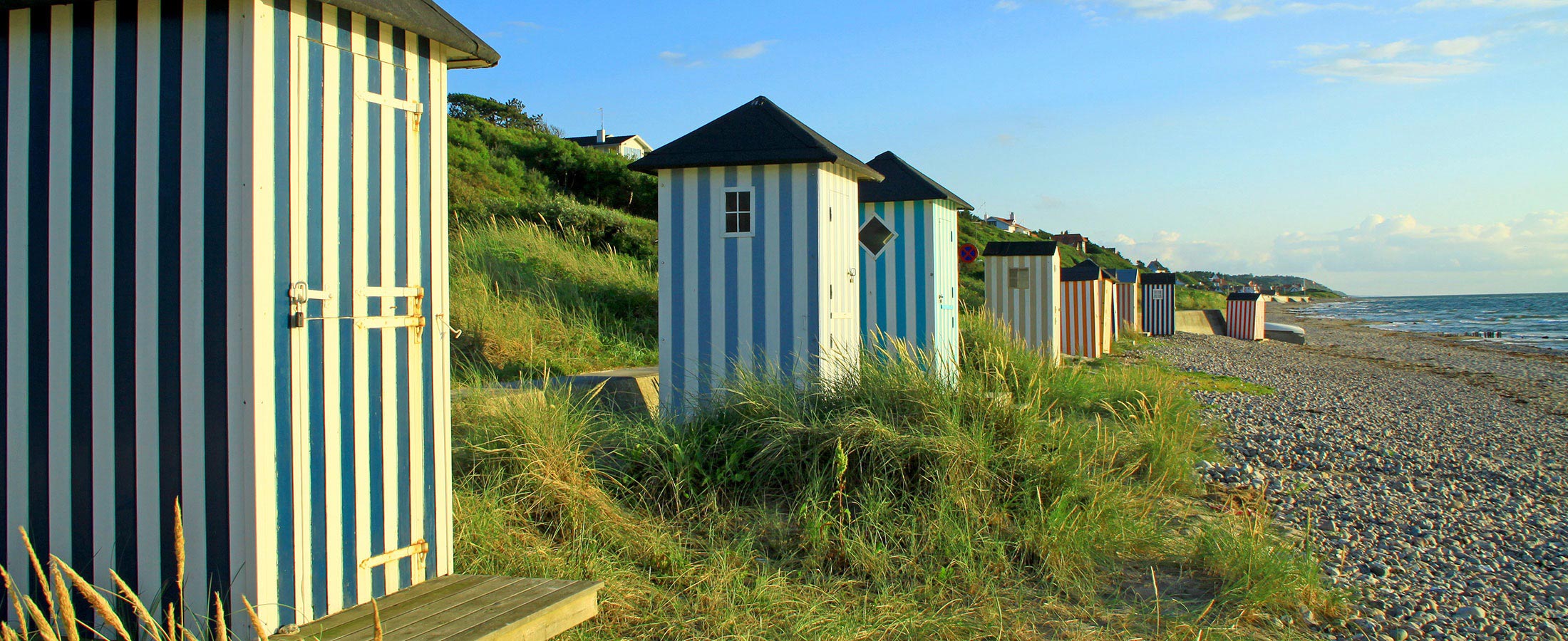 Traditionelle, gestreifte Strandhäuser auf dem Rågeleje Strand in Dänemark