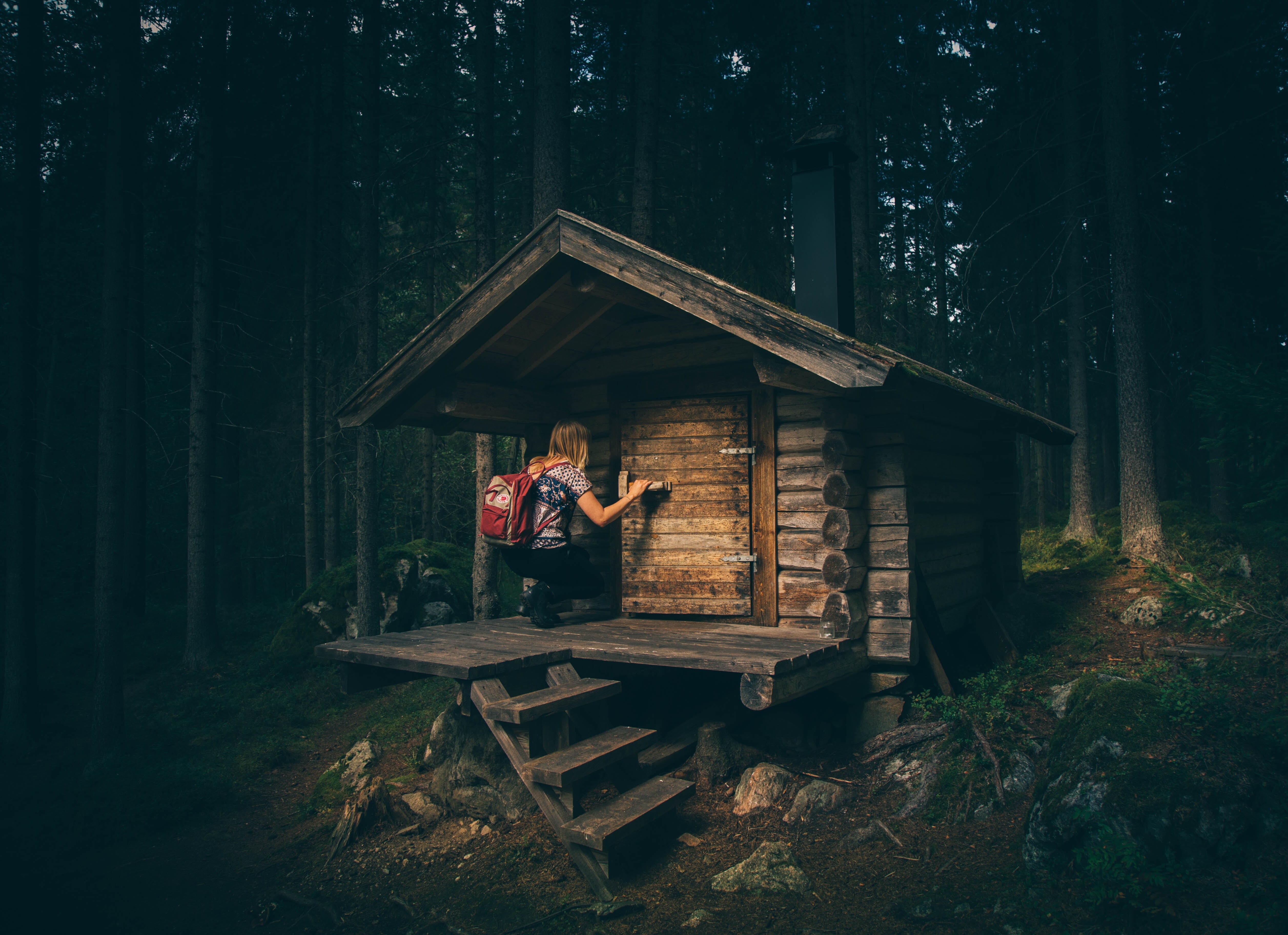 Eine Frau kommt rein in einer Holzhütte im Wald
