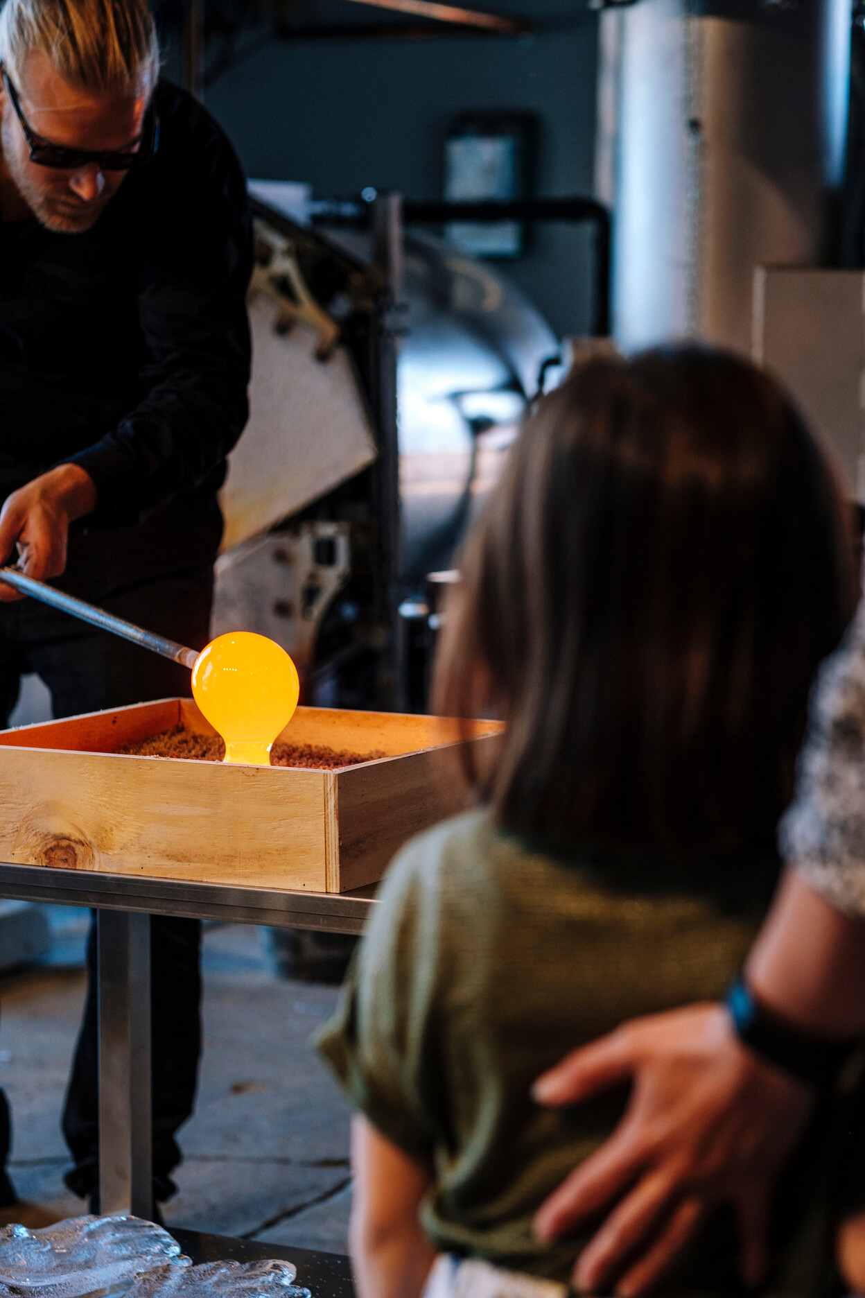 Mädchen mit der Familie schaut zu, wie man Glas im Holmegaard Vaerk produziert 