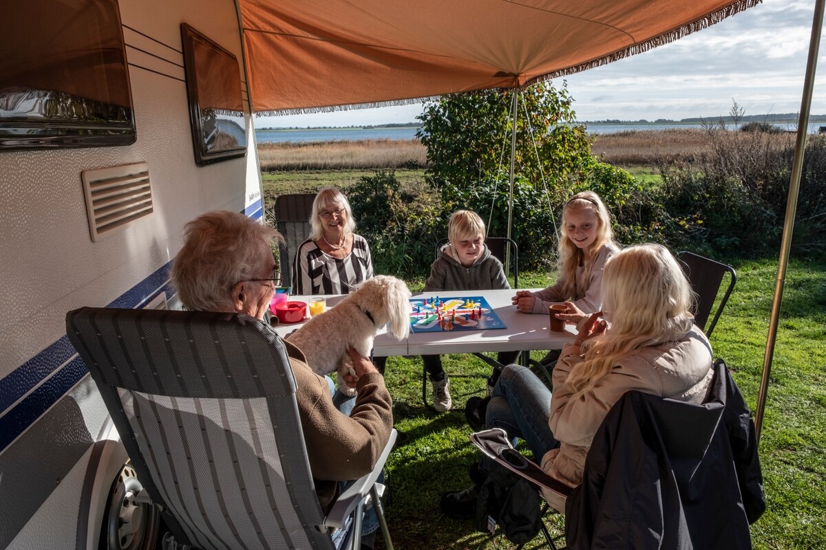 Familie spielt Brettspiele vor Ihrer Wohnmobil auf dem Campingplatz in Dänemark