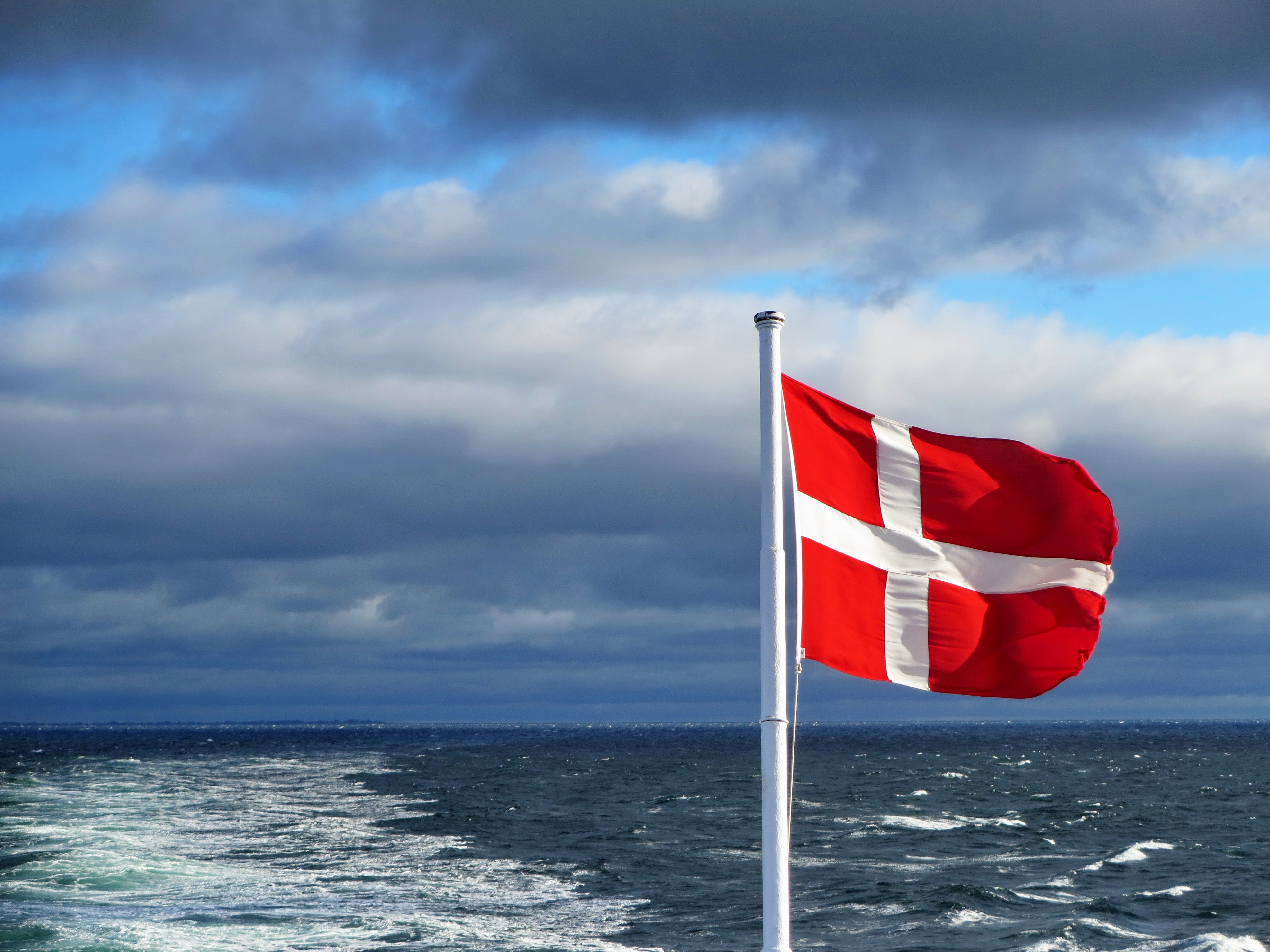 Dänische Flagge bei einer Fähre mit dem Meerblick