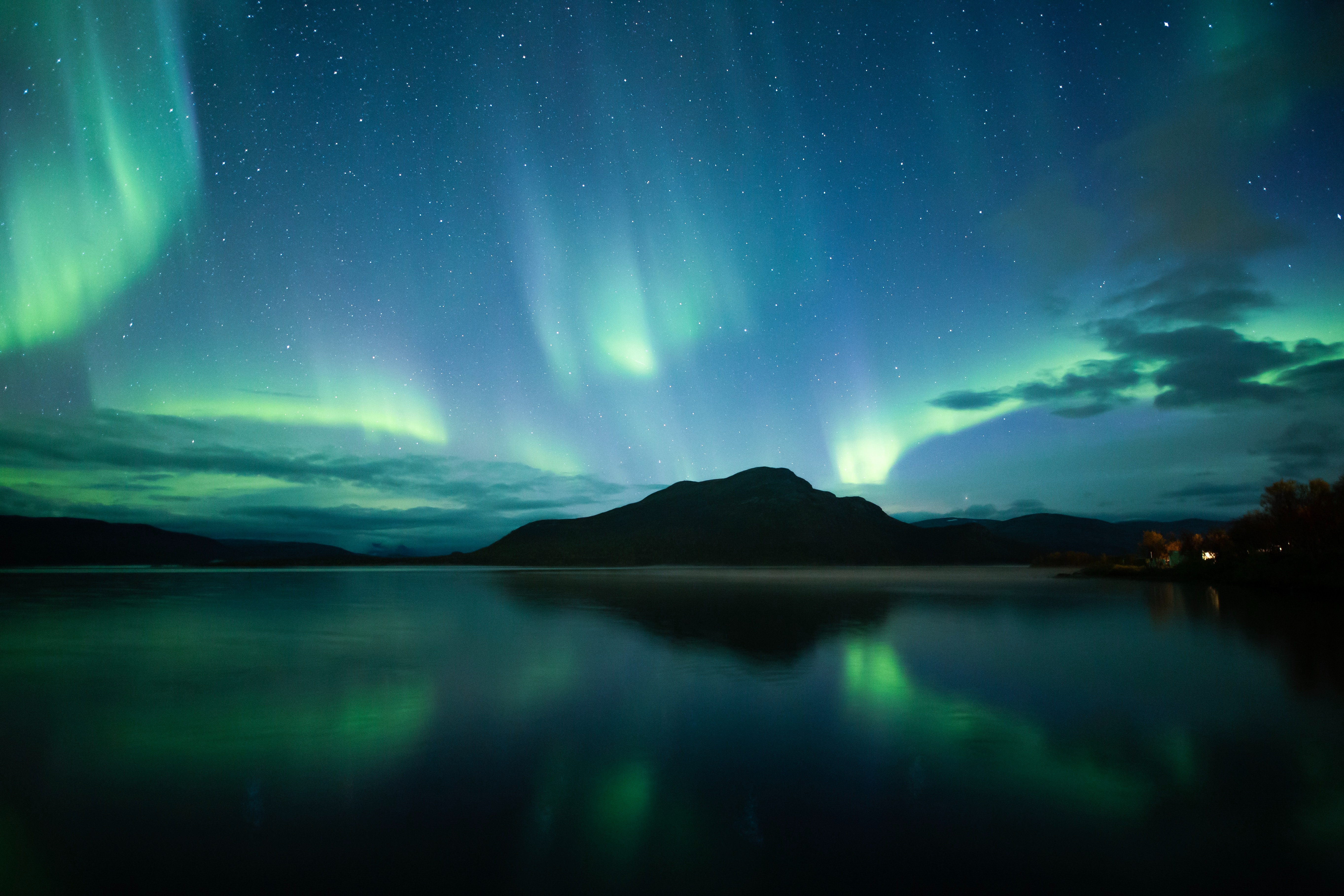 Buntes Polarlicht nachts beim Wasser zu sehen in Lappland in Skandinavien