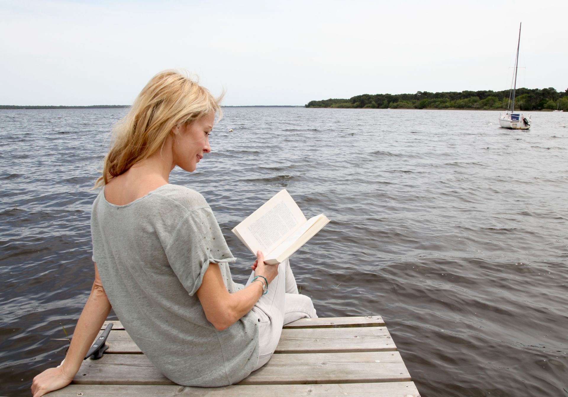 Kvinde læser ved sø