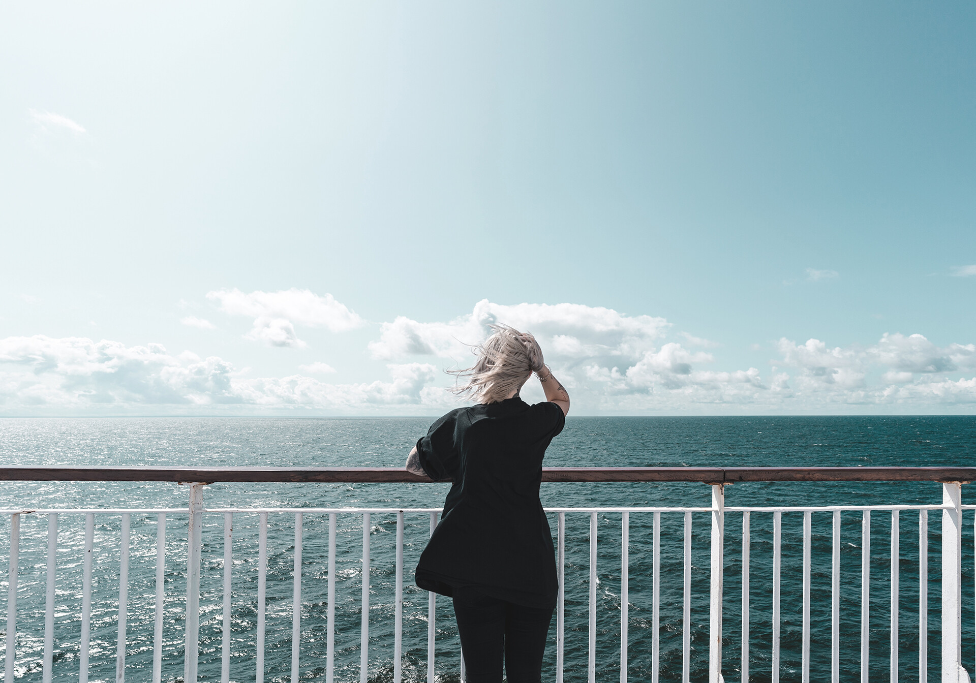 Kvinde på færgedæk ser ud over havet